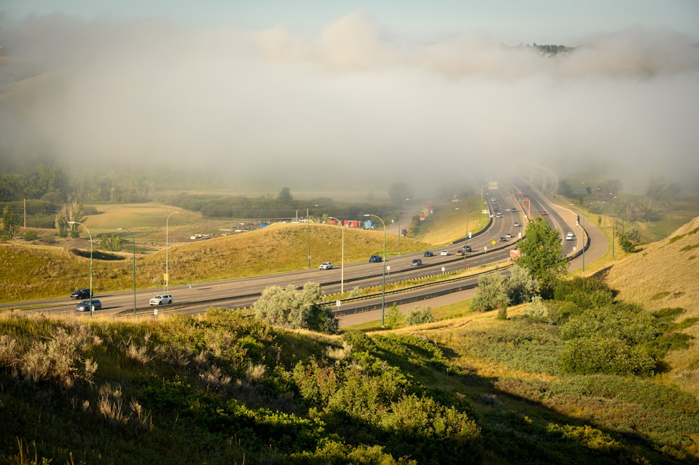 Vehículos en la carretera bajo el cielo blanco durante el día