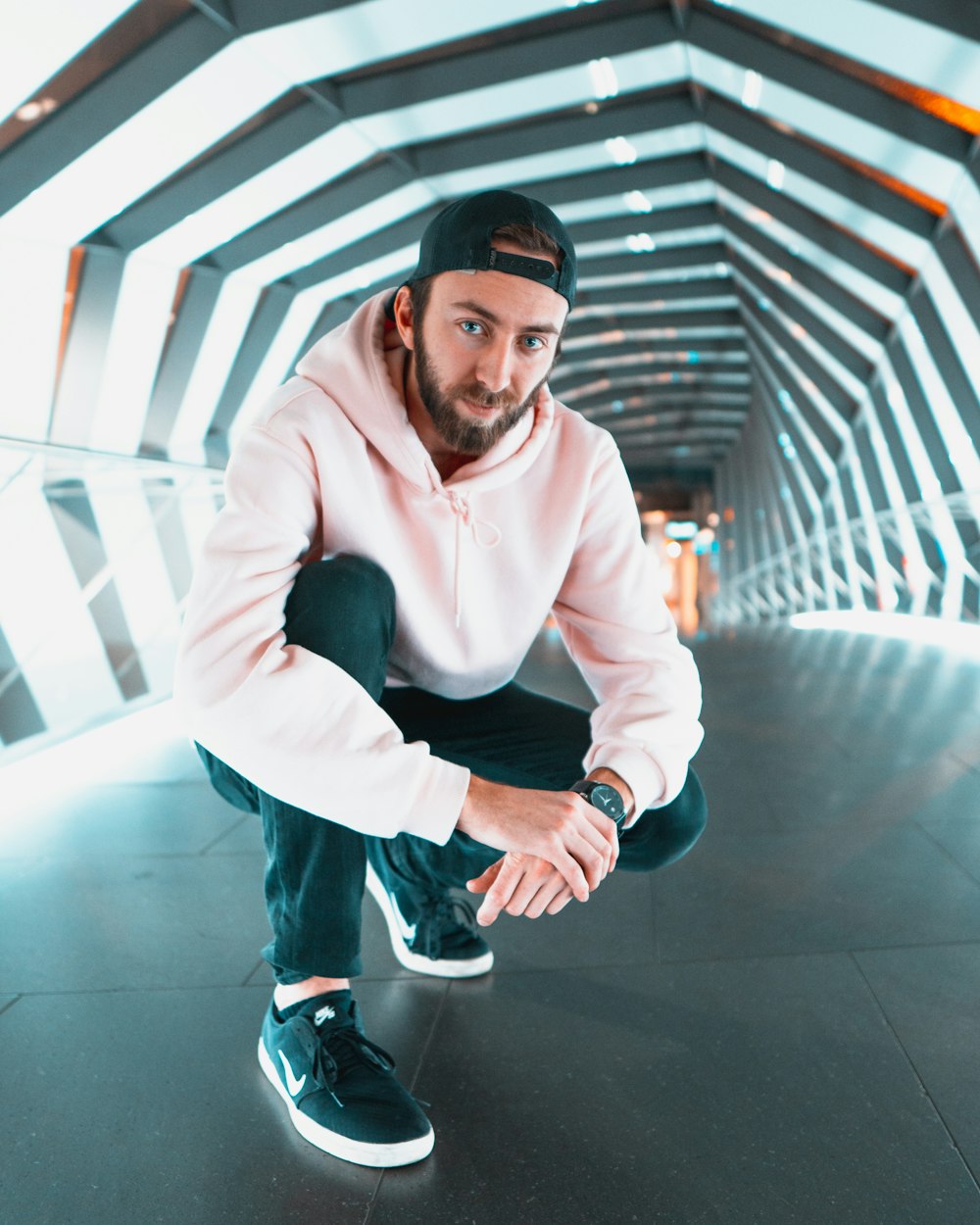 man wearing pink hooded jacket and blackpants