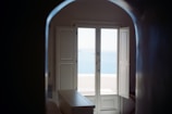 Sunlight streaming through balcony doors overlooking the ocean.