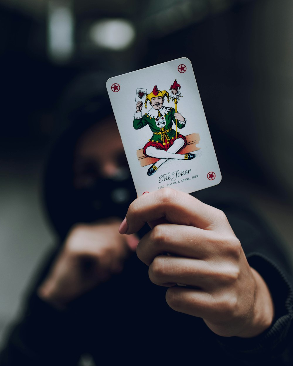 a person holding a playing card in their hand