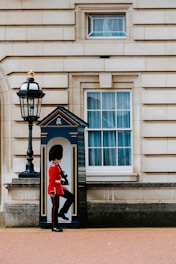 man wearing red and black top standing in front of white door