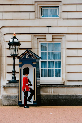 man wearing red and black top standing in front of white door England