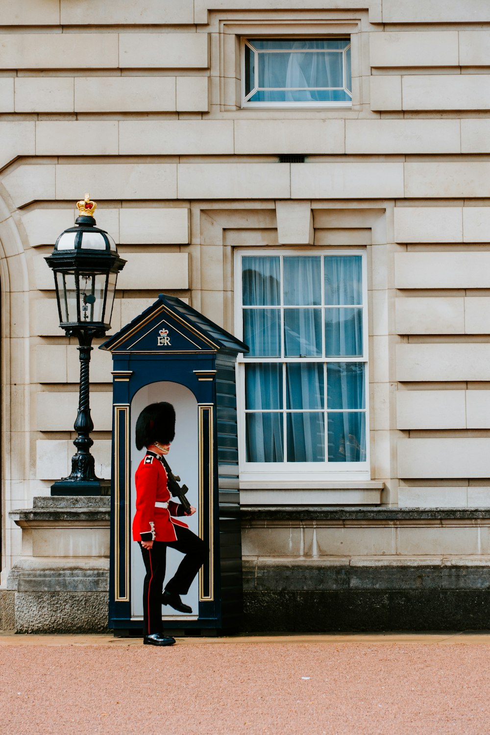 man wearing red and black top standing in front of white door