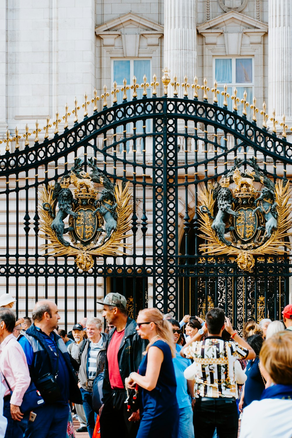 people standing in front of black and gold metal gate