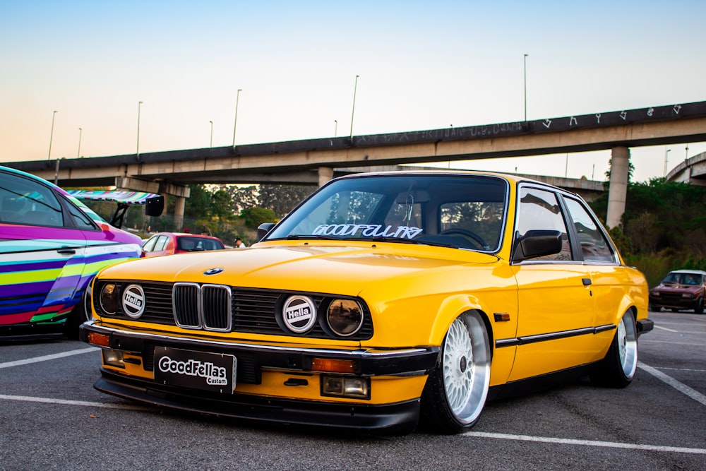 yellow BMW New Six coupe parking near road