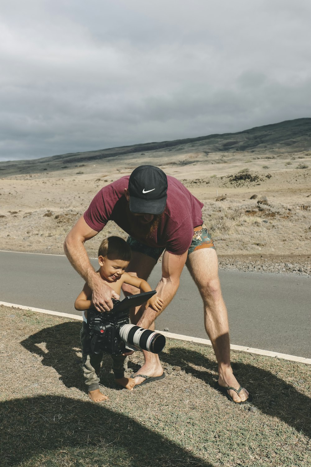 man and child holding preofessionalc amera