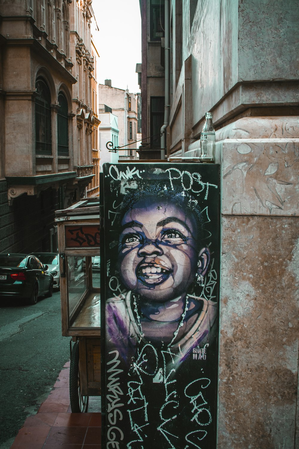 smiling baby hanging sign on street