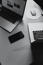 turned-off smartphone between mackbook