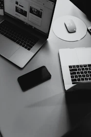 turned-off smartphone between mackbook