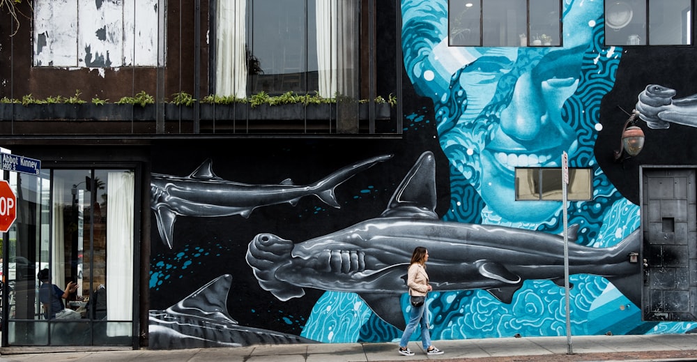 man standing near whale graffiti