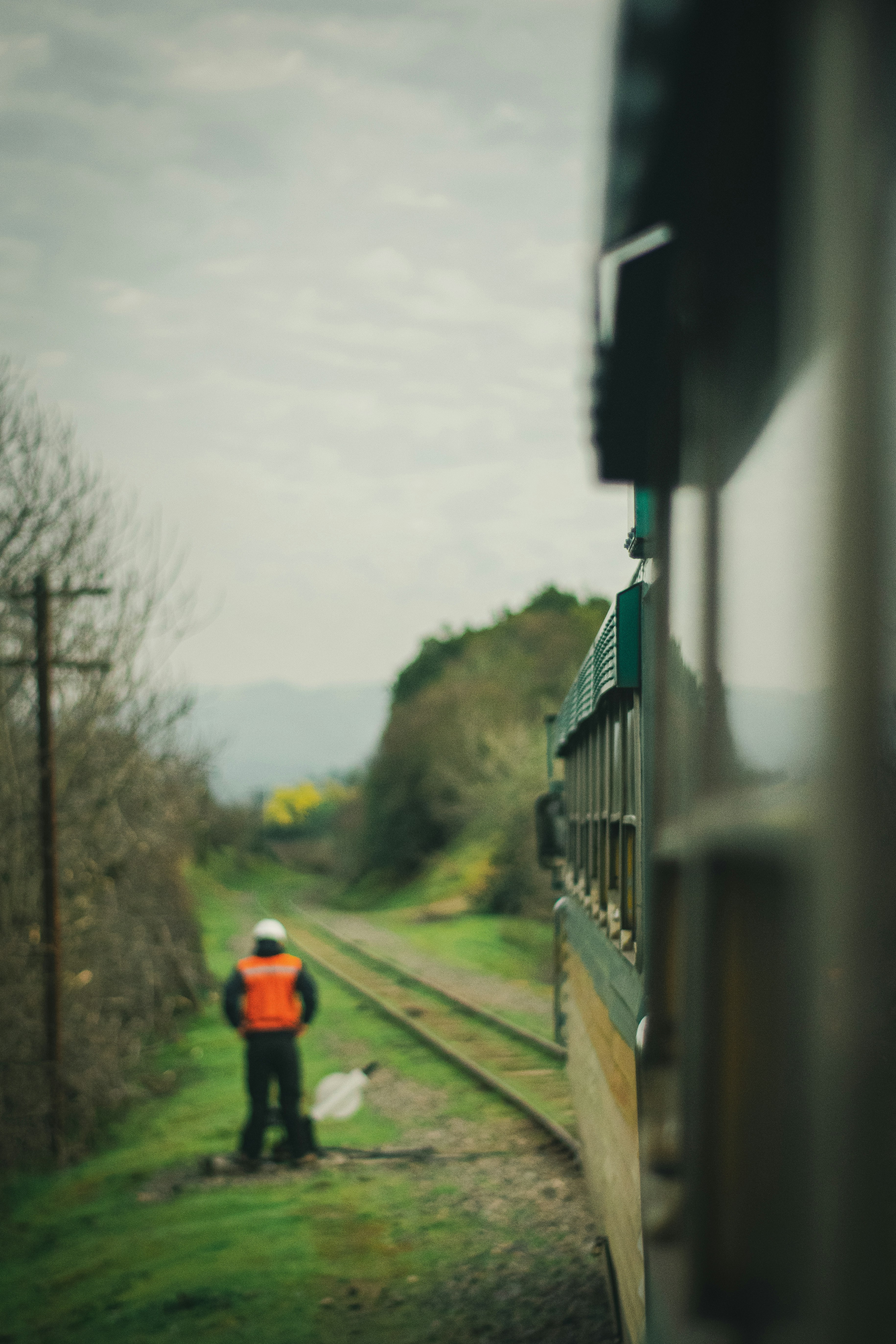 Person standing beside train rail near train during daytime photo ...