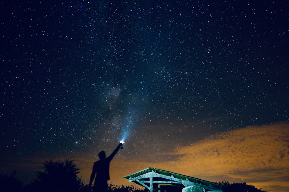 man holding flashlight outdoor during nighttime