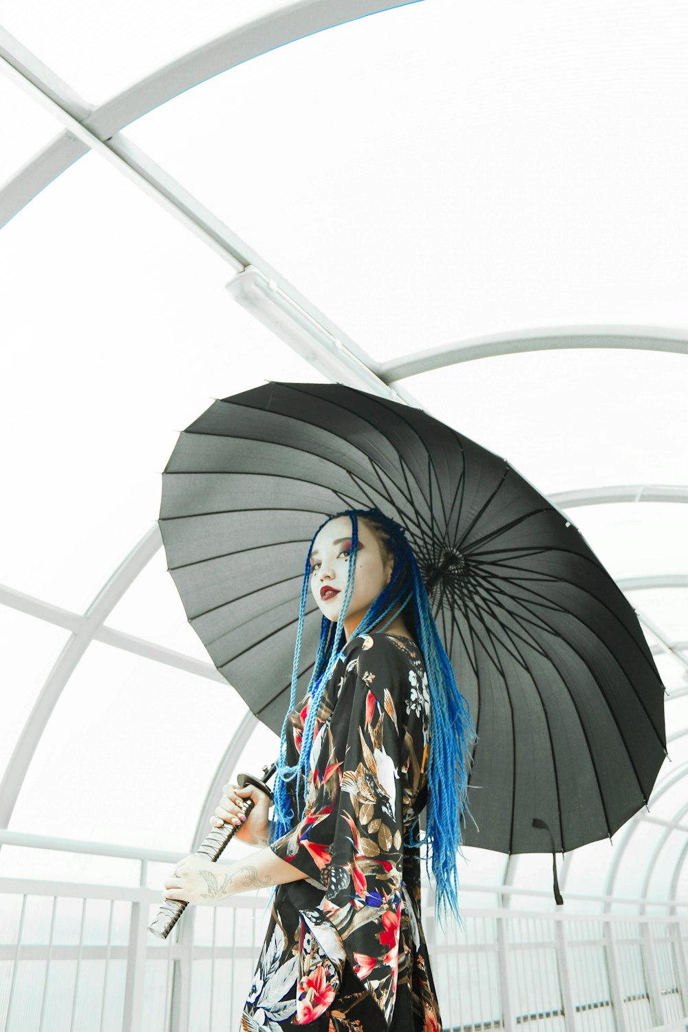 Muchacha sosteniendo paraguas de papel gris