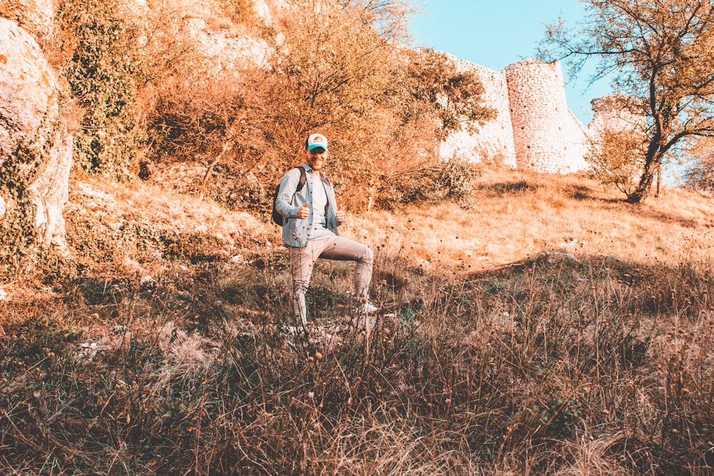 man standing under tree on hill