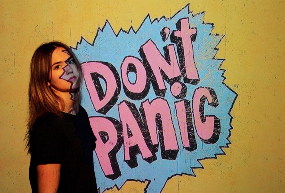 woman wearing black crew-neck t-shirt with don't panic background