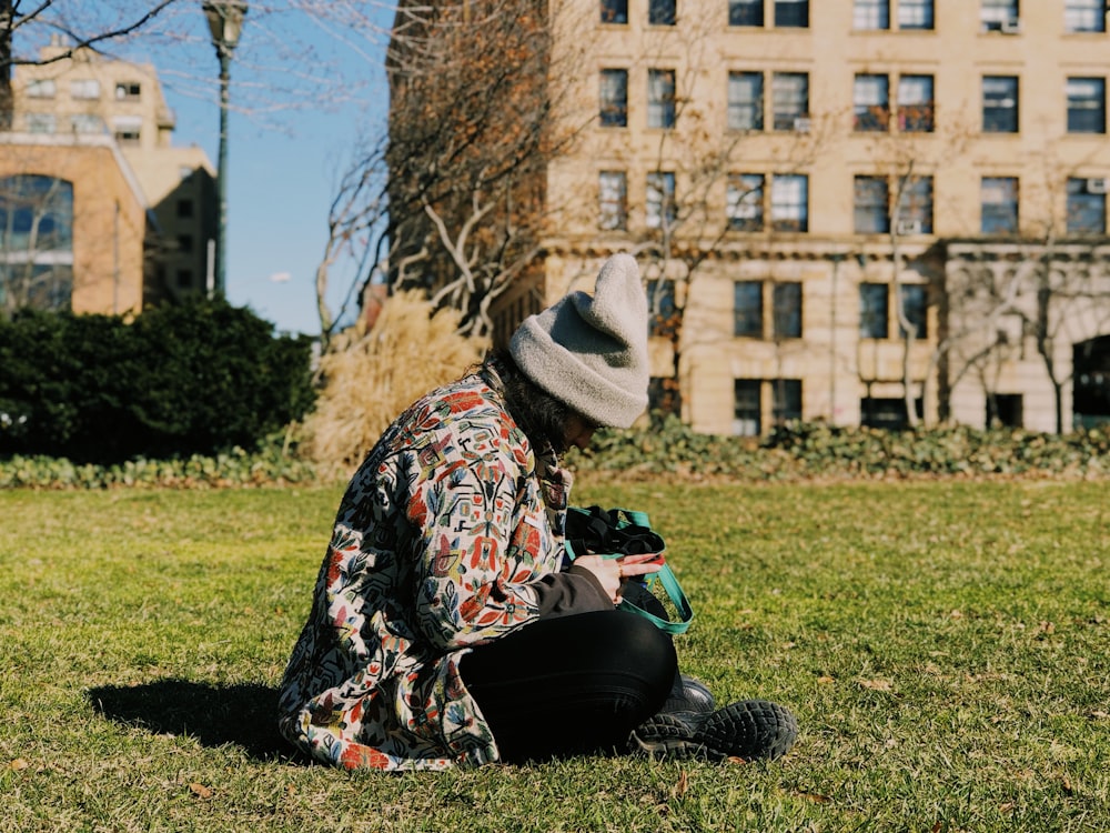 person sitting on grass field near building