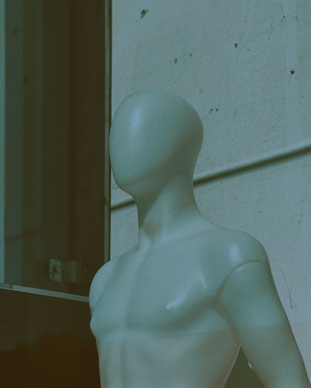 manikin standing beside wall