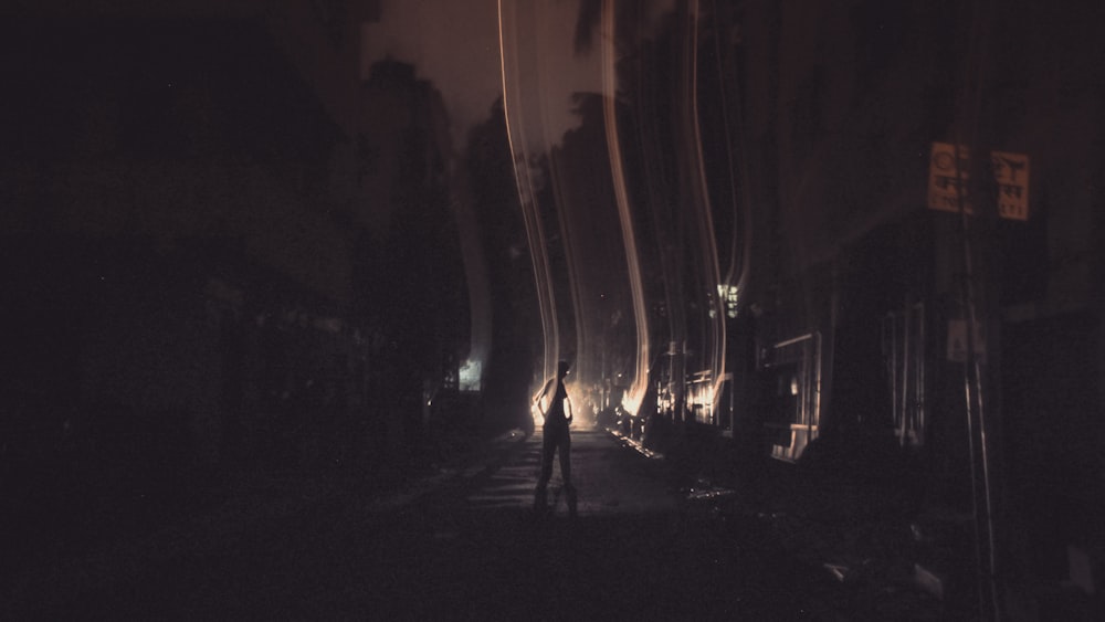 a person walking down a street at night