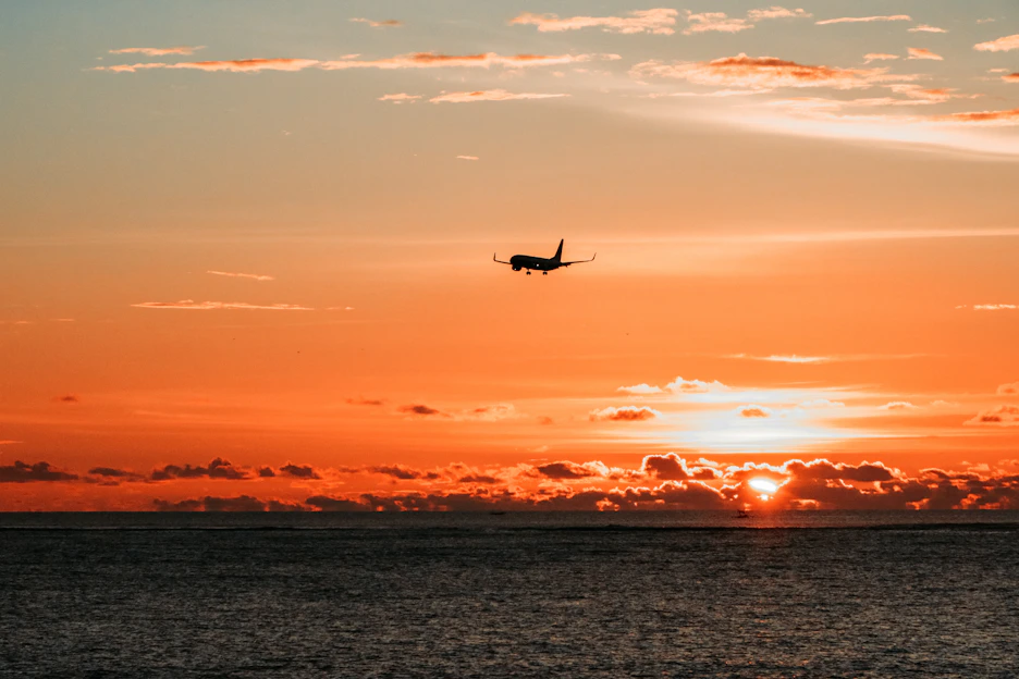 airplane on mid air above body of water