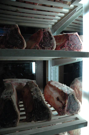Interior view of the frigorífico showing clean, organized cold storage with meat racks.