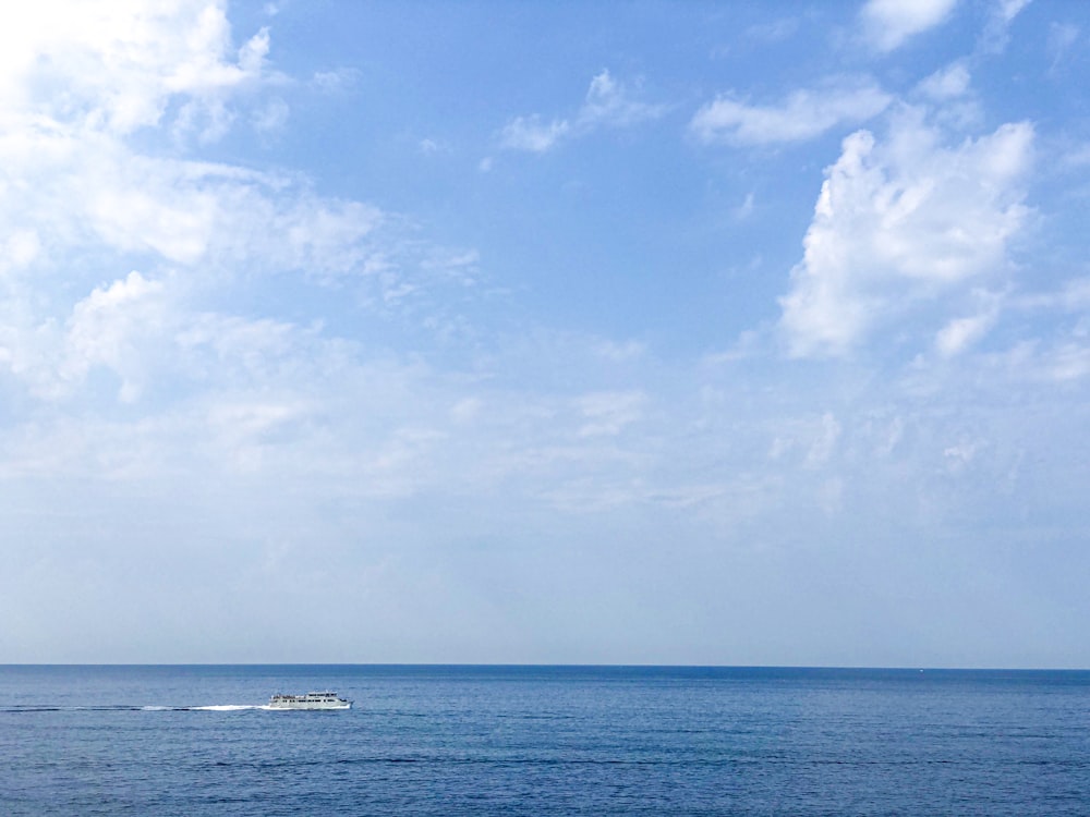 boat on sea under cloudy sky