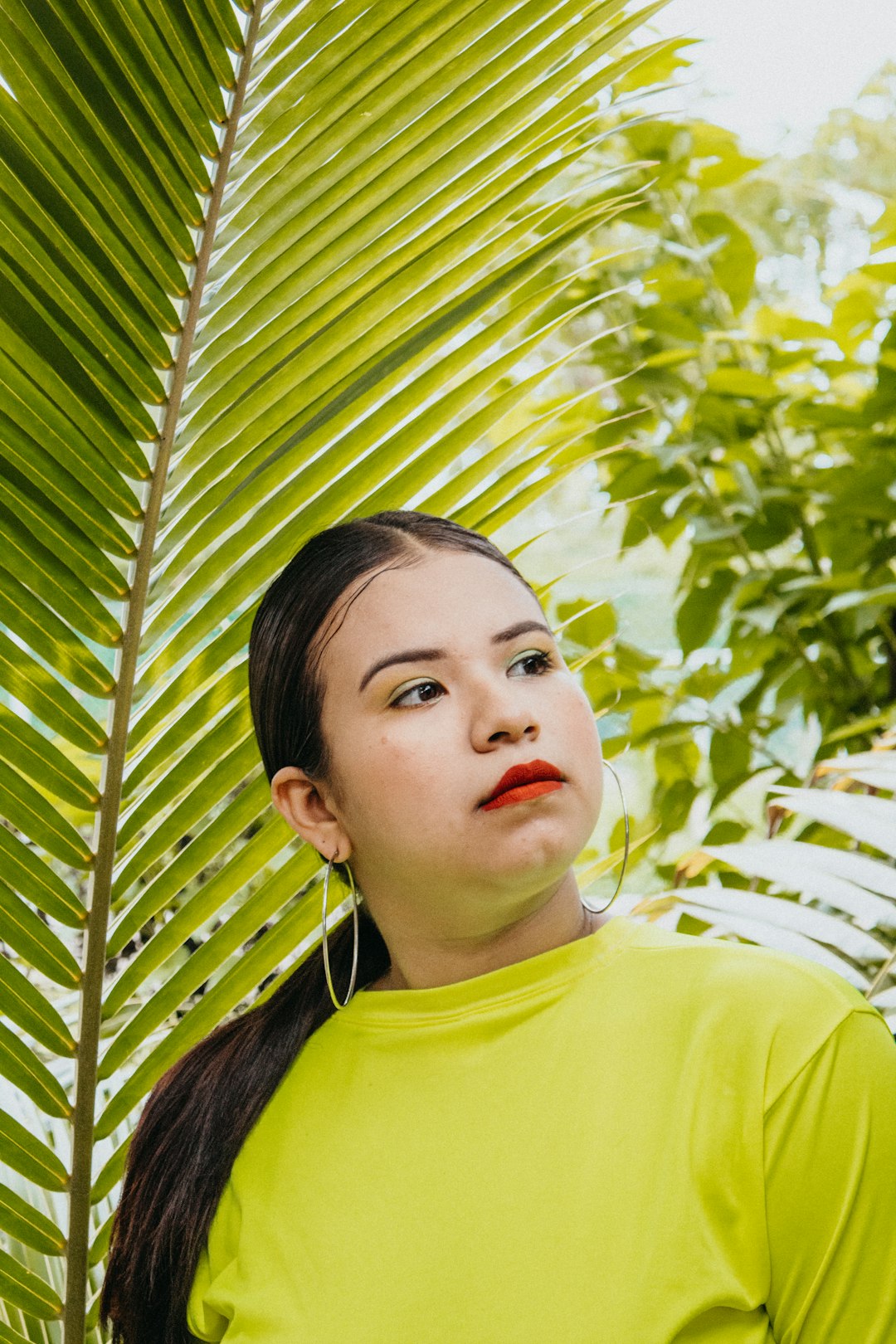 woman standing near palm leaf