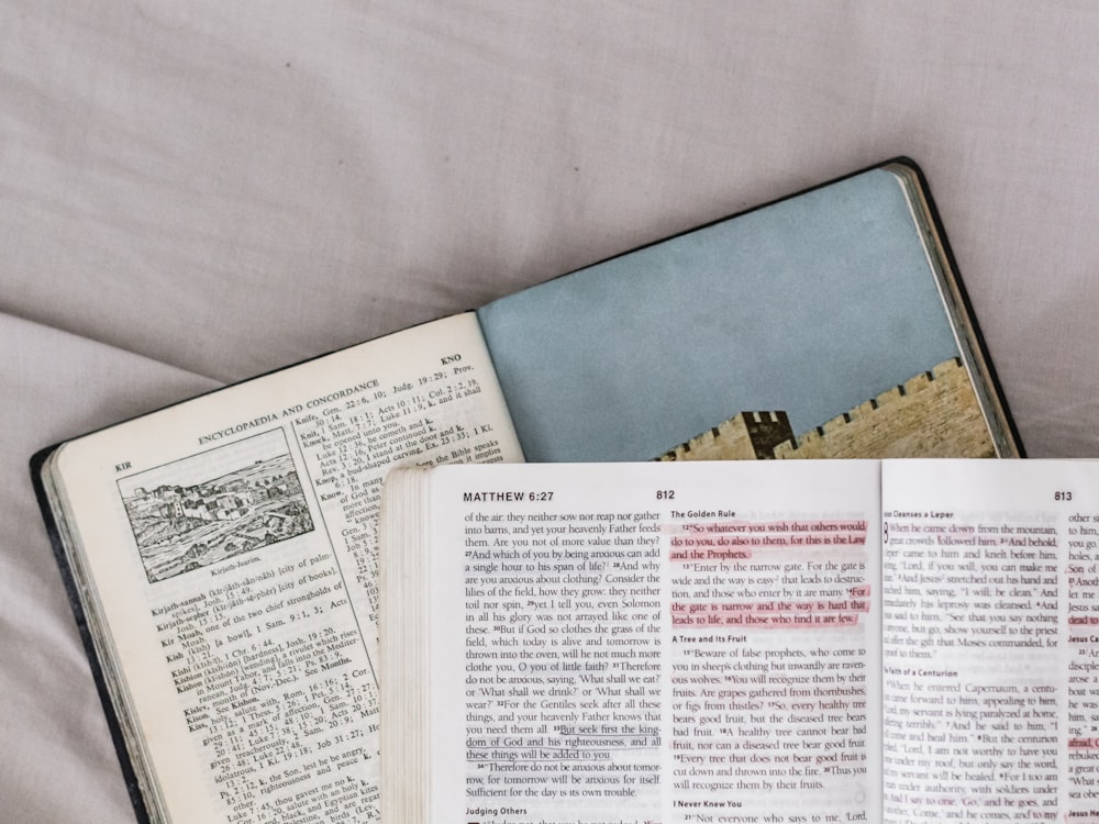 an open book sitting on top of a bed next to an open book