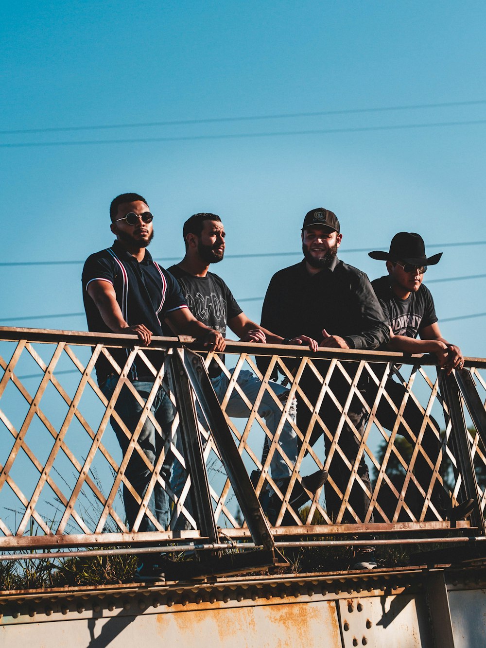 four men holding on metal handrail