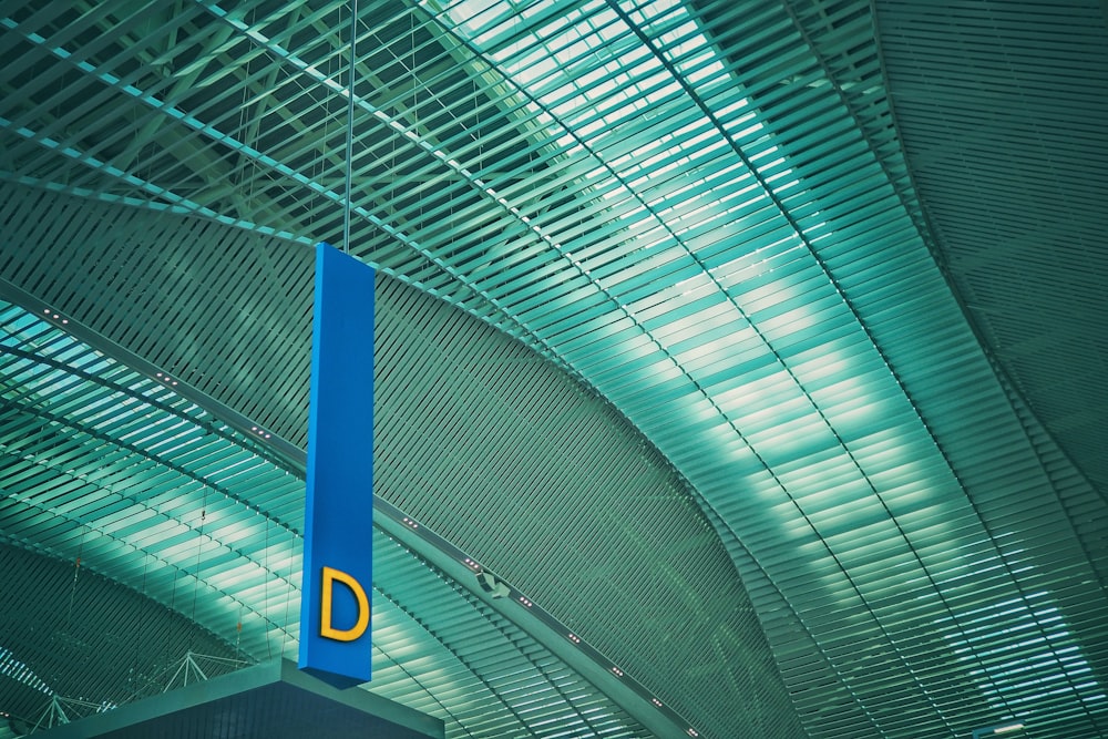 a blue sign hanging from the ceiling of a building