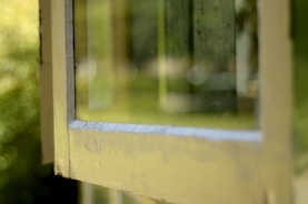 A close-up of a window being cleaned, showing clear reflections.