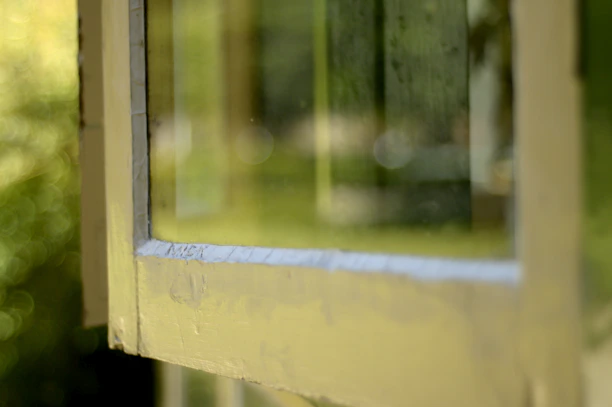 Close-up of shiny aluminum window frame with sunlight reflecting off its surface.