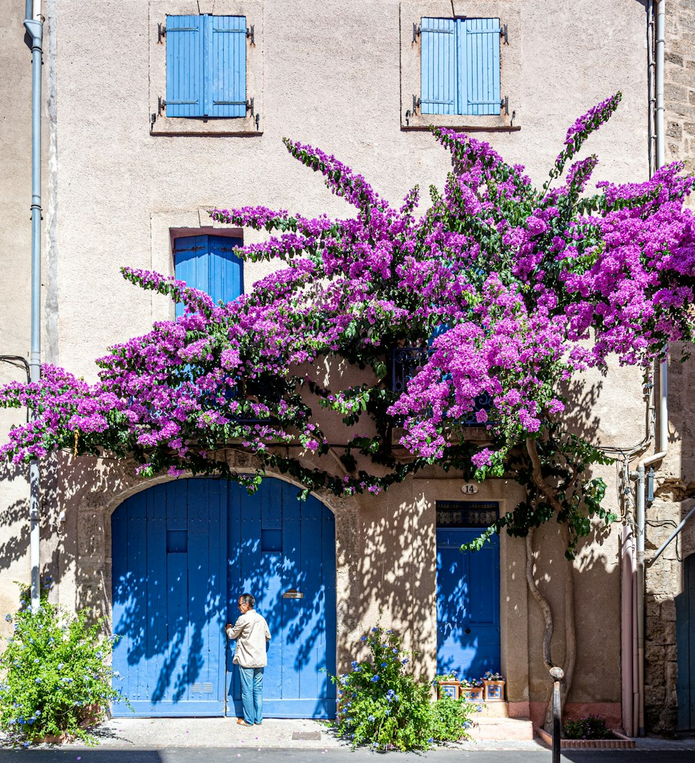 man standing infront of blue door