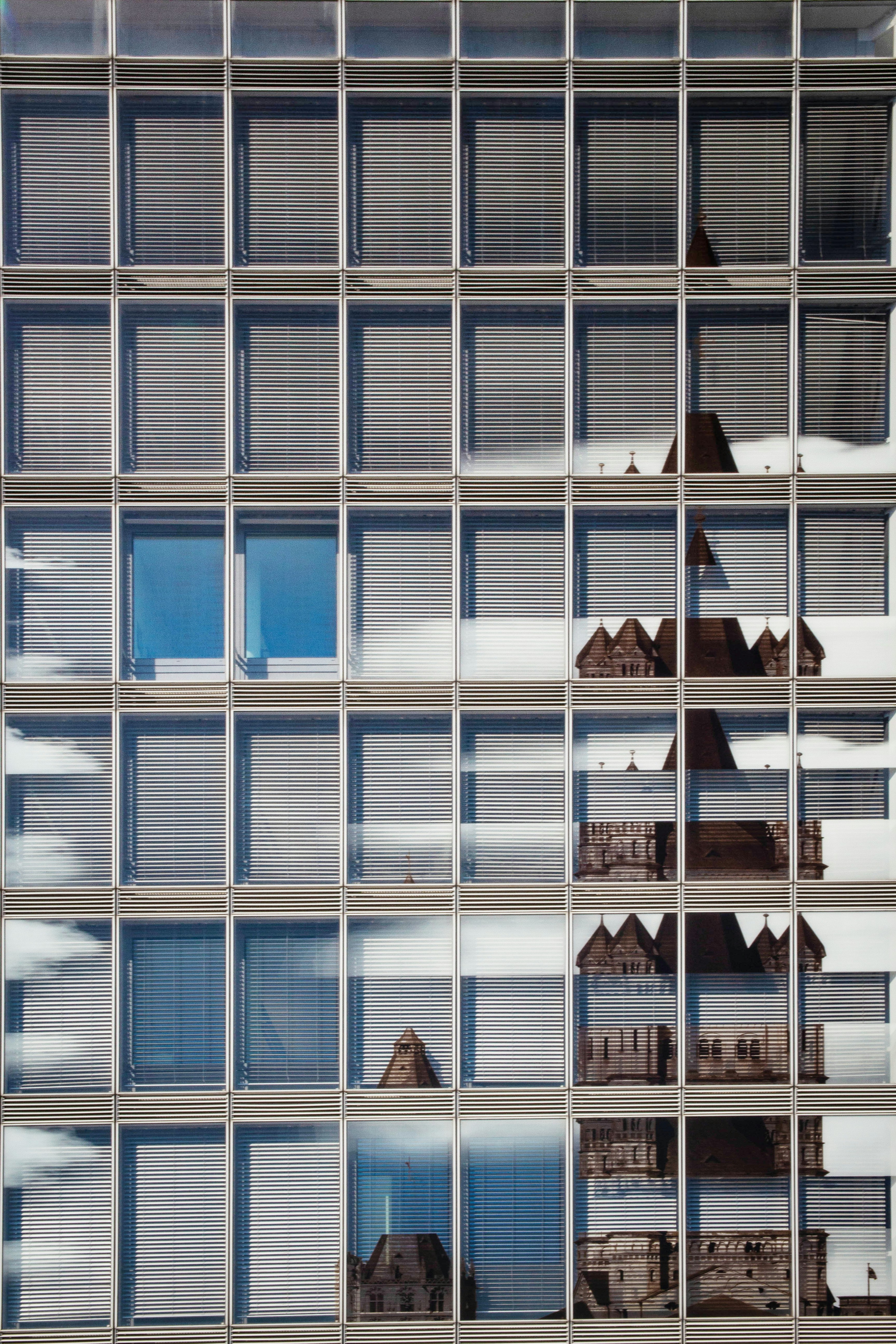 Modern glass windows reflecting an ornate historic building.