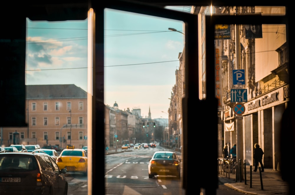 vehicles on road beside buildings under blue and white skies during daytime