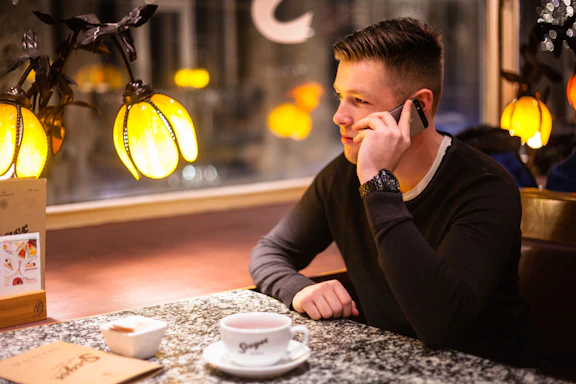 A friendly technician answering a phone call in a cozy repair shop.