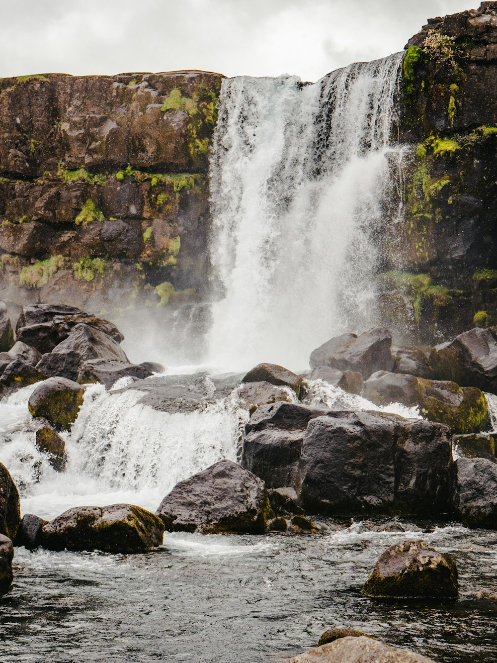 waterfall under gray sky