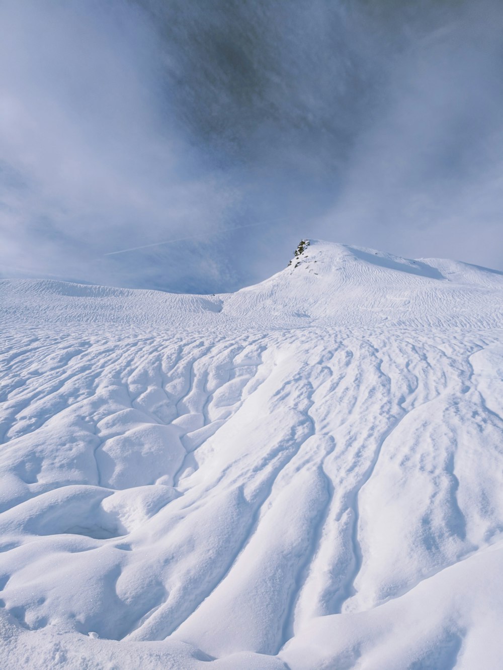 a person riding skis on top of a snow covered slope
