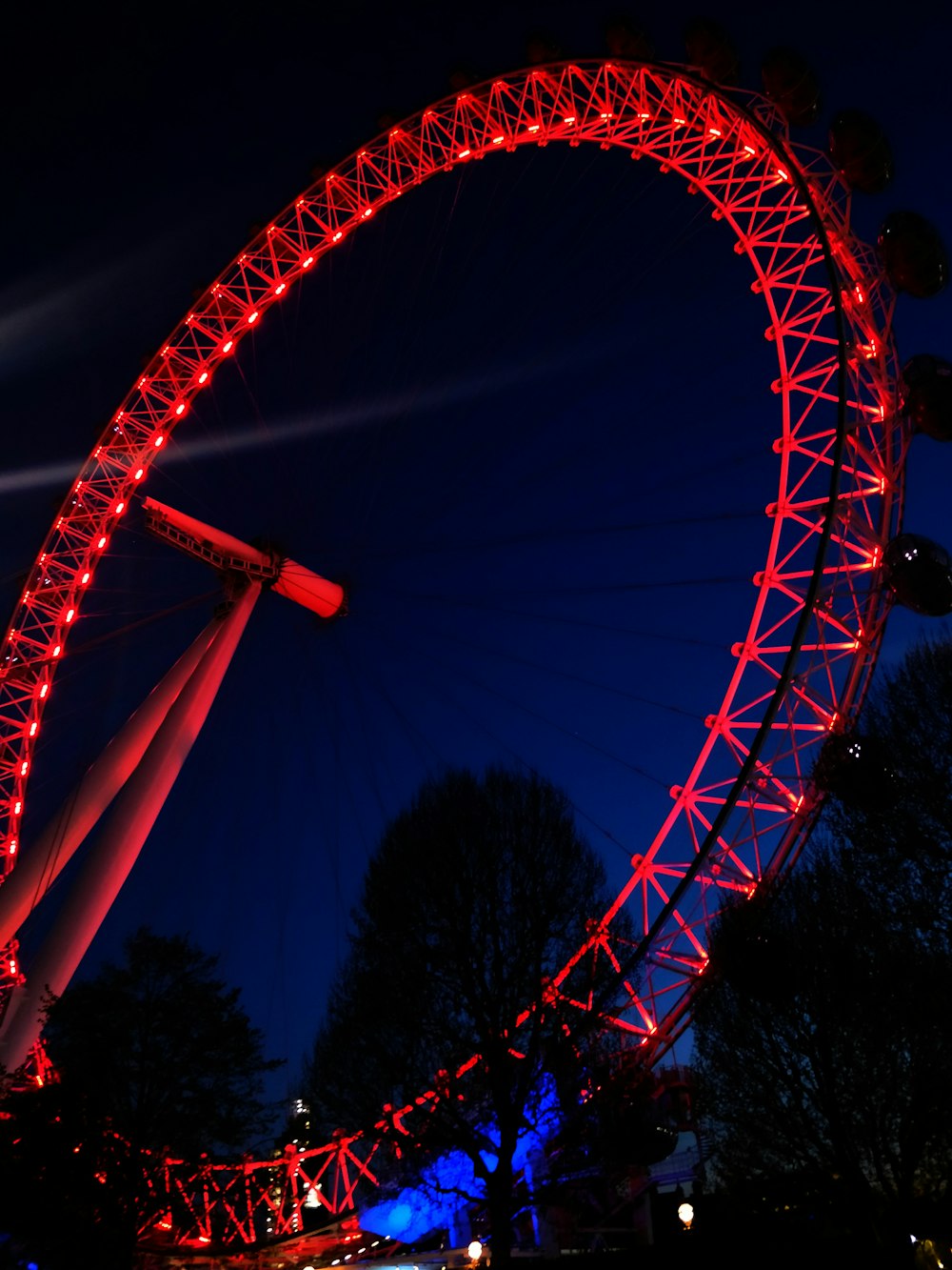 roda gigante iluminada em vermelho durante a noite