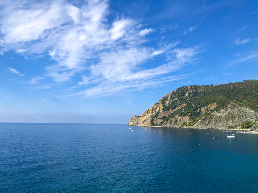 blue ocean near green mountain