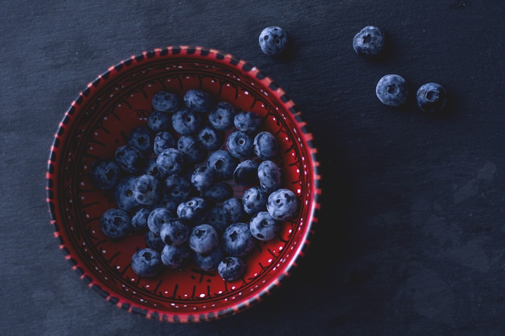 blueberries in red ceramic bowl
