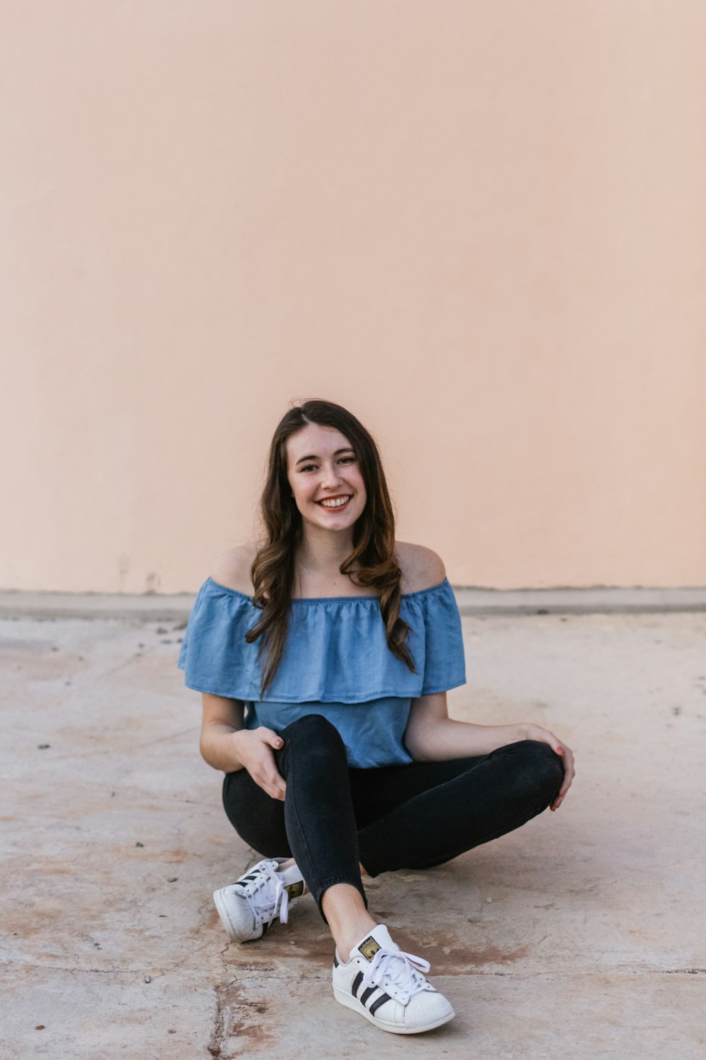 woman sitting on ground near wall