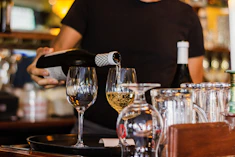 unknown person pouring beverage on glass