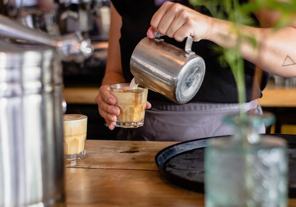 pouring milk on glass cup