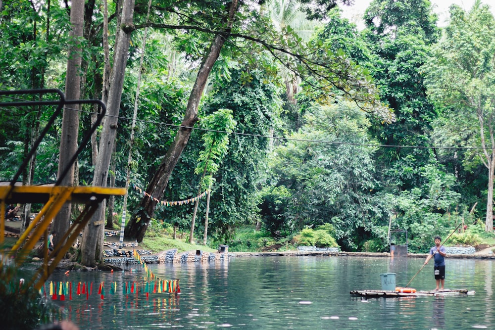 man on floating bamboo