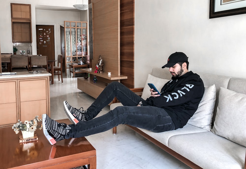 man sitting on sofa while leaning on table