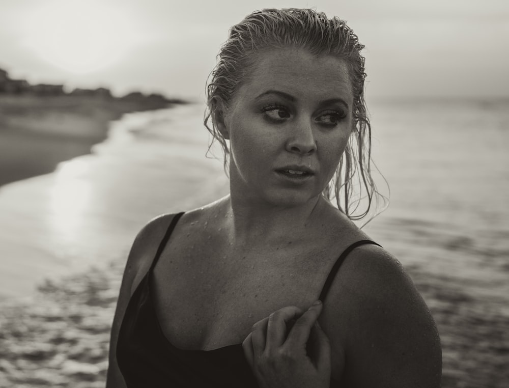 grayscale photography of woman in black top at shore