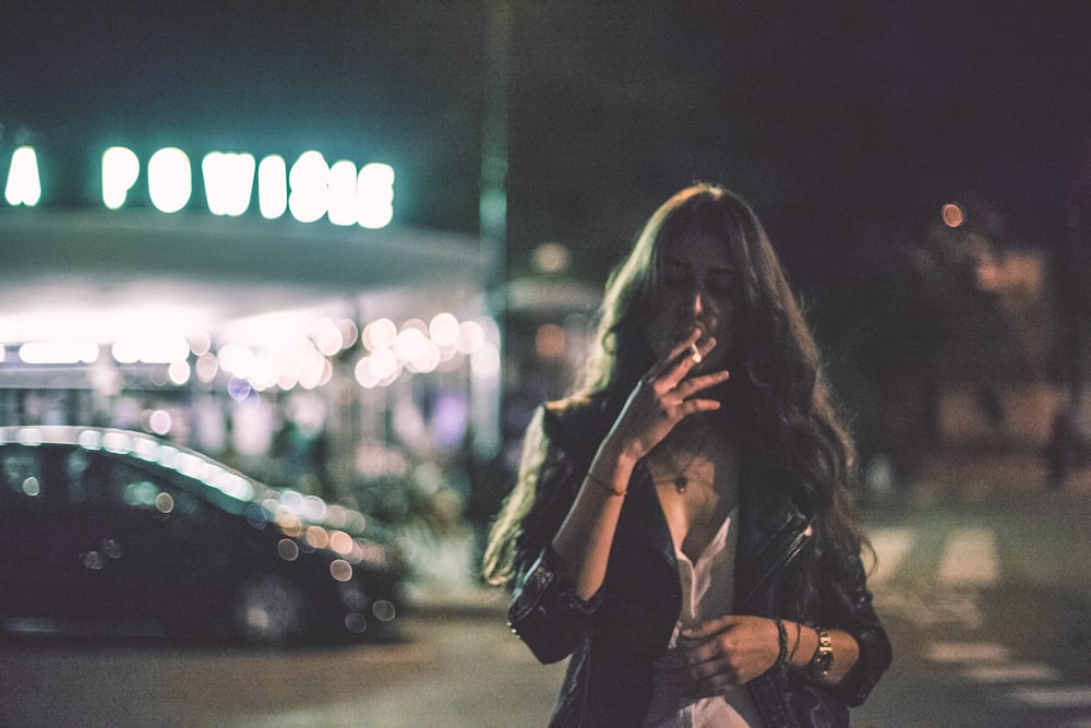 woman smoking near vehicle