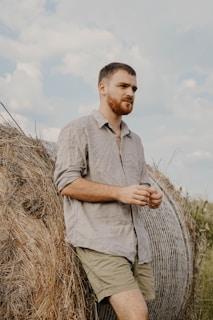 man leaning on hay bale