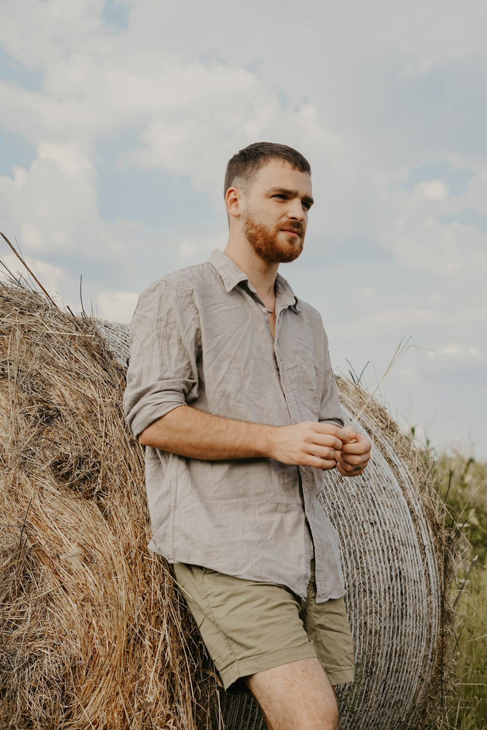 man leaning on hay bale