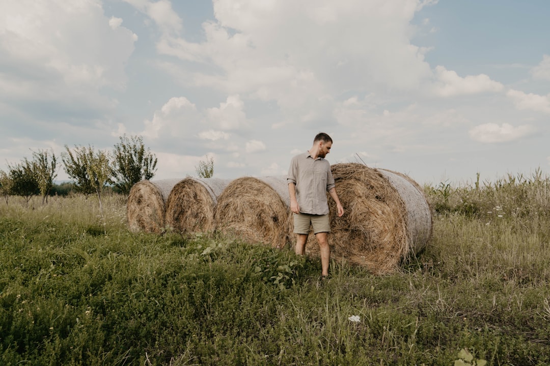 man standing near the stock hay